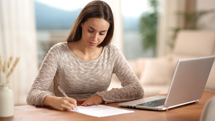 Person filling in form while sat at a laptop
