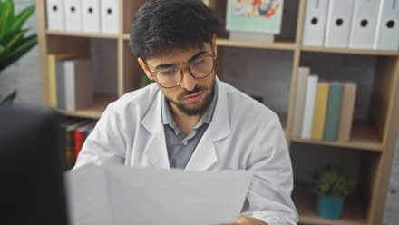 Person in a lab coat reading a document