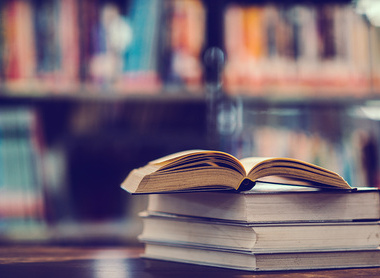 Pile of books on a desk in a library