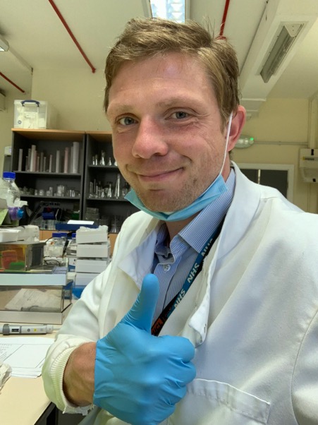 Matt Clarke giving a thumbs up while working in the lab