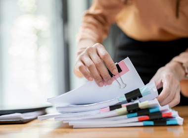 Person looking through pile of physical documents