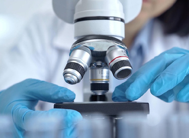 Researcher adjusting slide under microscope