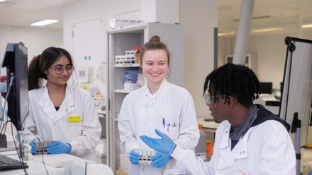 Three laboratory technicians talking in a lab