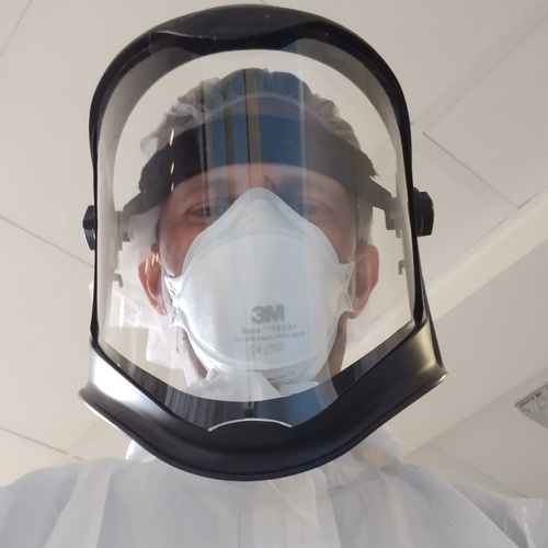 Dr Skittrall wearing PPE while assessing patients for infectious diseases in his clinical practice
