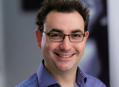 Dr Joel Newman smiling at the camera