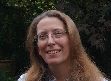 Dr Lucy Leeman in front of trees smiling at the camera