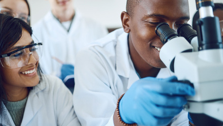 Trainees looking down a microscope