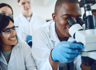 Trainees looking down a microscope