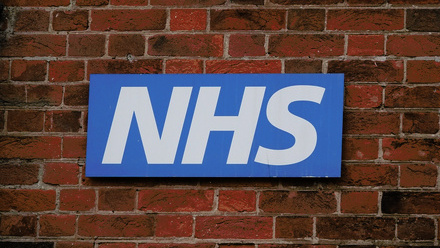 NHS logo on brick wall