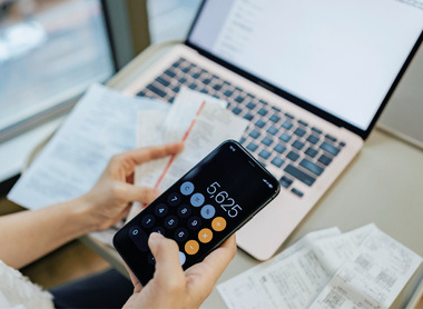 Person holding a calculator and receipts