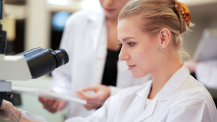 Trainee pathologist being supervised at microscope