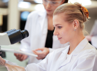 Trainee pathologist being supervised at microscope