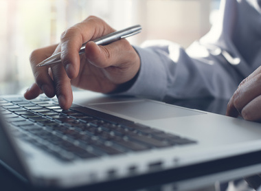 Writing a meeting report on a laptop