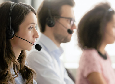 Staff sitting at computers with headphones