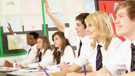 School children in a classroom listening