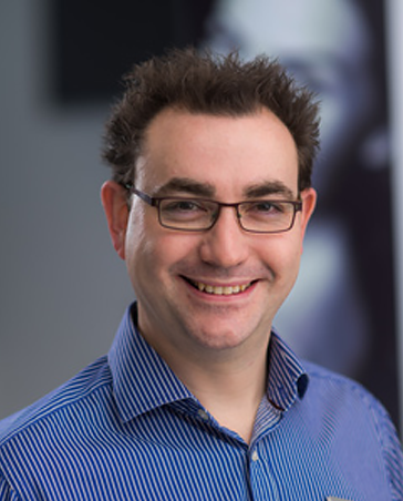 Dr Joel Newman smiling at the camera