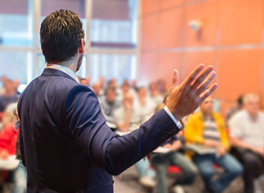 Person giving a lecture in front of a small audience