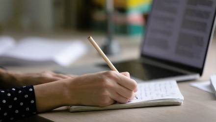 Person writing an essay on lined paper