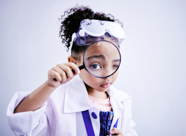 Child in lab coat with magnifying glass.jpg