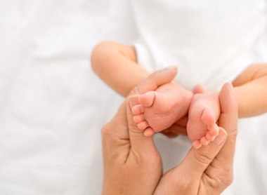 Small feet of a newborn baby being held