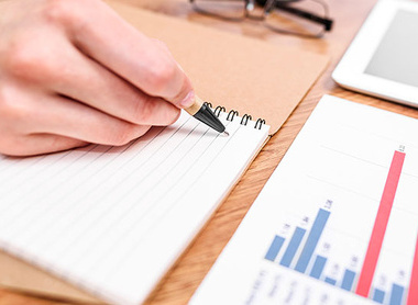 Person evaluating a report with bar graphs
