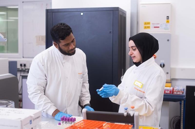 Biomedical scientists discussing samples in a lab