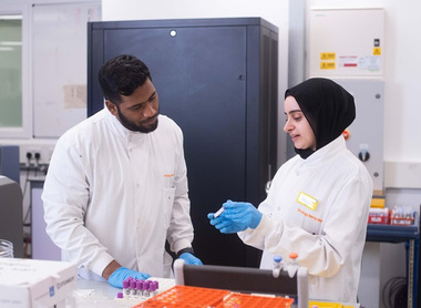 Biomedical scientists discussing samples in a lab