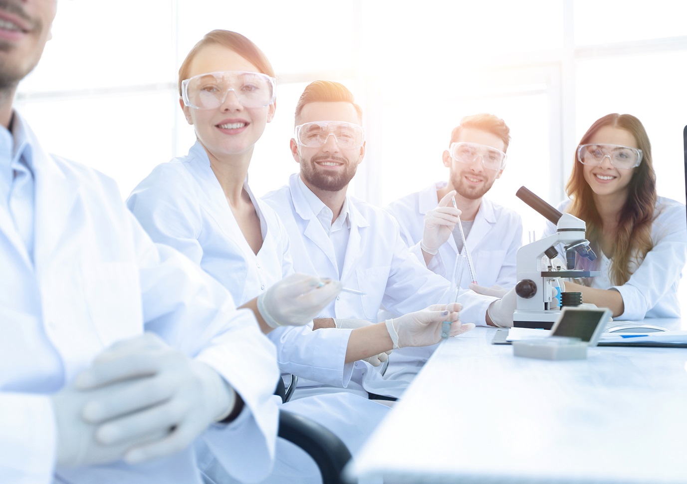 Group of scientist in front of microscope