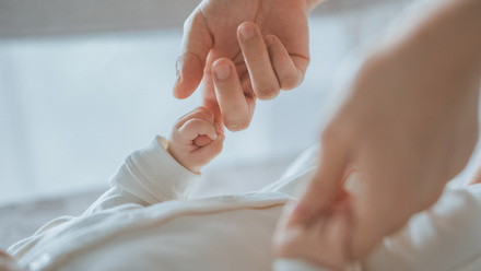 Person holding a baby's hands