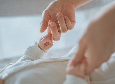 Person holding a baby's hands