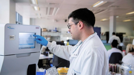 Medical laboratory assistant using UF 5000 machine in microbiology lab