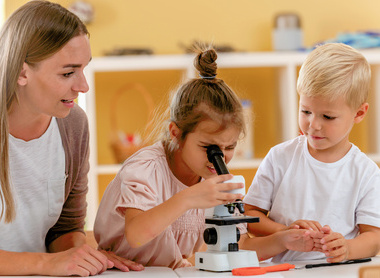 Young children looking down microscope.jpg