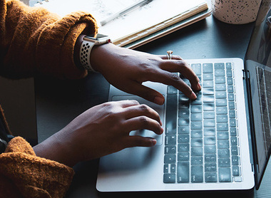 Doctor typing notes at a laptop