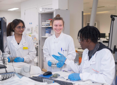  Three laboratory technicians talking in a lab