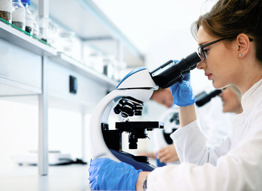 People looking down microscope in lab.jpg