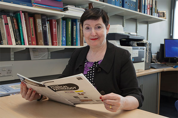 Professor Jo Martin reading at their desk