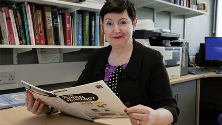 Professor Jo Martin reading at their desk